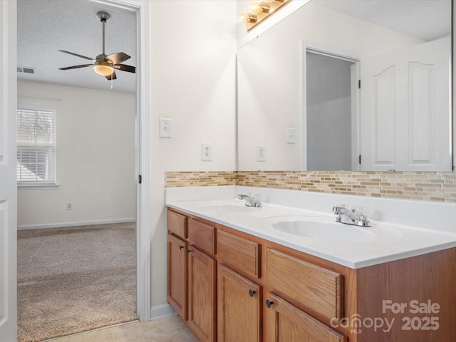 bathroom featuring decorative backsplash, visible vents, and a sink