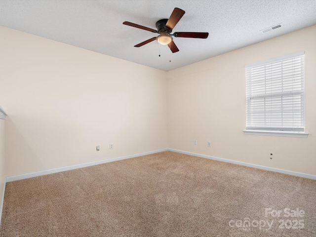 unfurnished room featuring visible vents, baseboards, carpet, a textured ceiling, and a ceiling fan