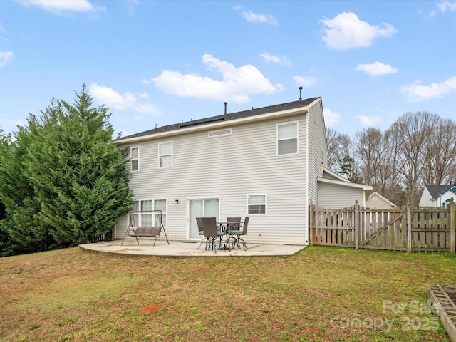 rear view of house featuring a yard, a patio, and fence