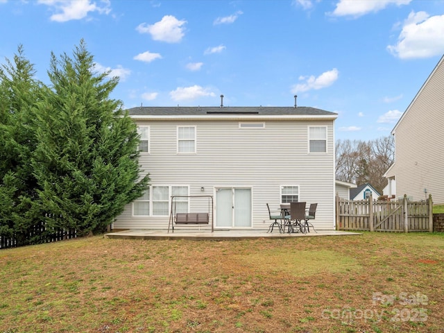 rear view of property with a yard, fence, and a patio area