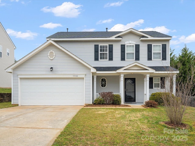 traditional-style house featuring a front yard, an attached garage, and driveway