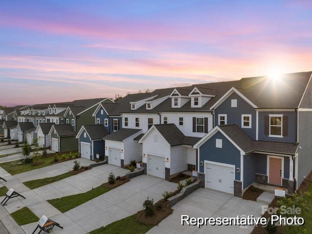 multi unit property featuring stone siding, a garage, a residential view, and driveway