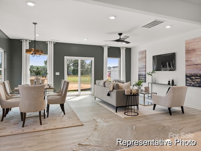 dining area featuring light wood finished floors, visible vents, recessed lighting, and ceiling fan with notable chandelier