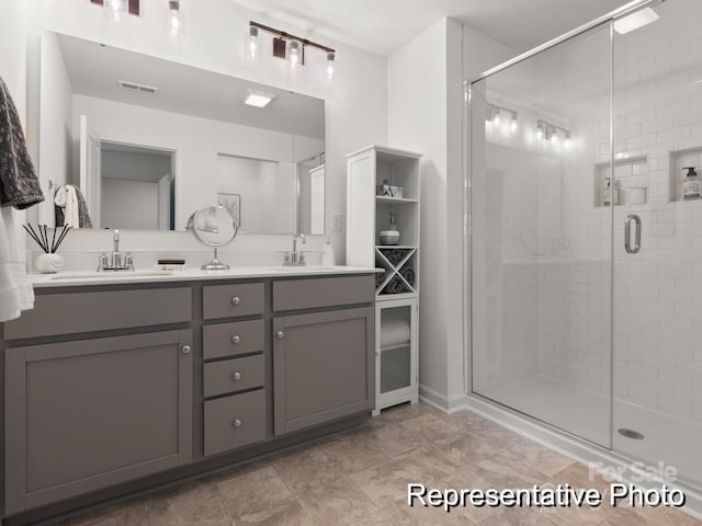 full bathroom featuring double vanity, visible vents, a shower stall, and a sink