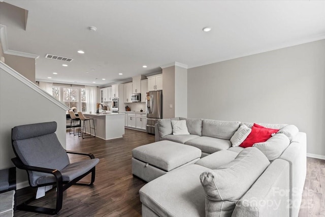 living area with dark wood finished floors, recessed lighting, visible vents, and baseboards