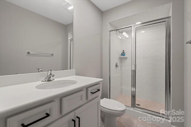 full bath featuring tile patterned floors, vanity, toilet, and a shower stall