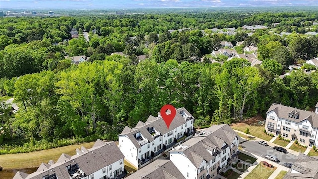 birds eye view of property with a residential view and a wooded view