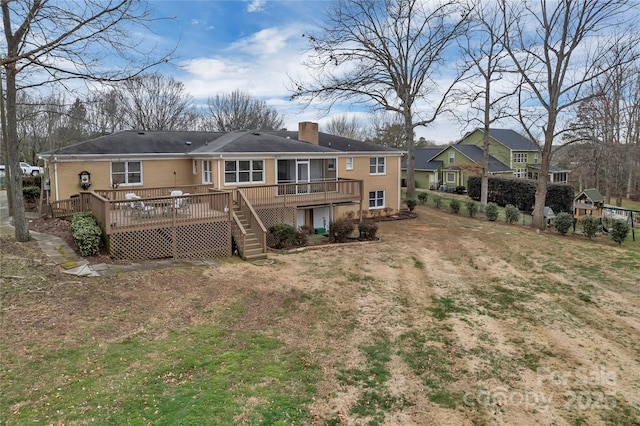 back of house with stairway, a chimney, and a deck