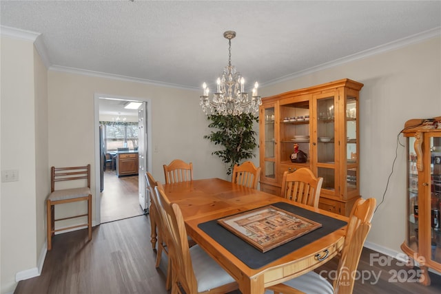 dining space featuring wood finished floors, a textured ceiling, a chandelier, and crown molding