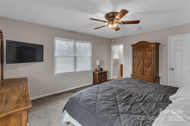 bedroom with a ceiling fan, ensuite bathroom, baseboards, and carpet floors