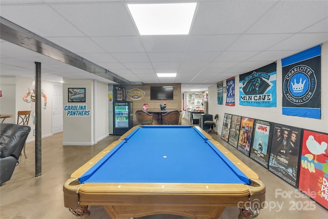 playroom featuring a bar, a paneled ceiling, and baseboards