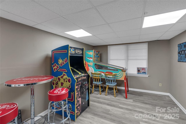 rec room featuring a paneled ceiling, baseboards, and wood finished floors