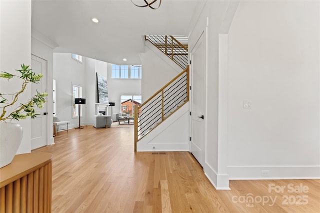 entrance foyer featuring recessed lighting, light wood-style flooring, stairs, and baseboards