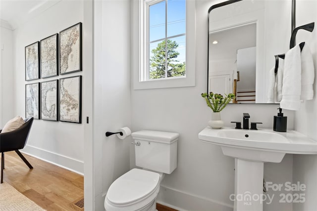 bathroom featuring baseboards, toilet, and wood finished floors