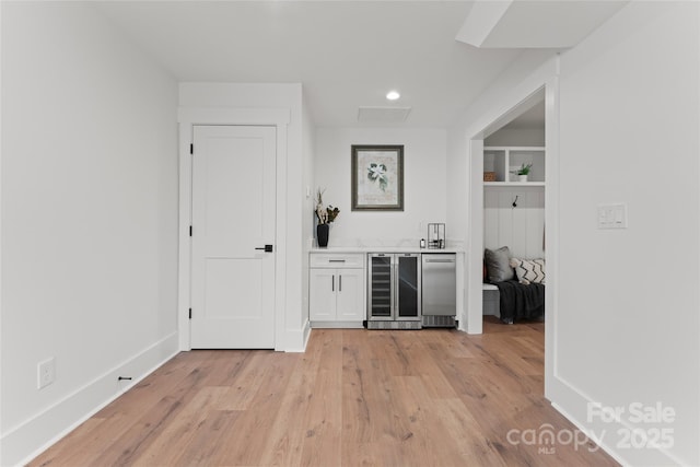 bar with fridge, light wood-type flooring, a bar, beverage cooler, and recessed lighting