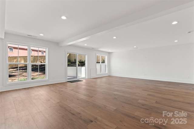 unfurnished living room with visible vents, wood finished floors, baseboards, and recessed lighting