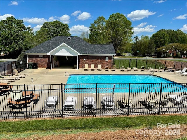 community pool featuring a patio and fence