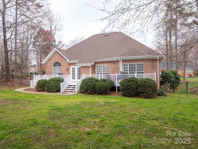 view of front of house featuring brick siding, a front yard, and fence