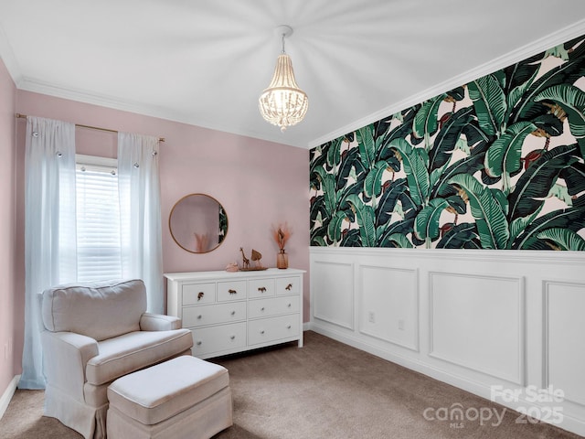 living area featuring crown molding, carpet, wainscoting, a notable chandelier, and a decorative wall