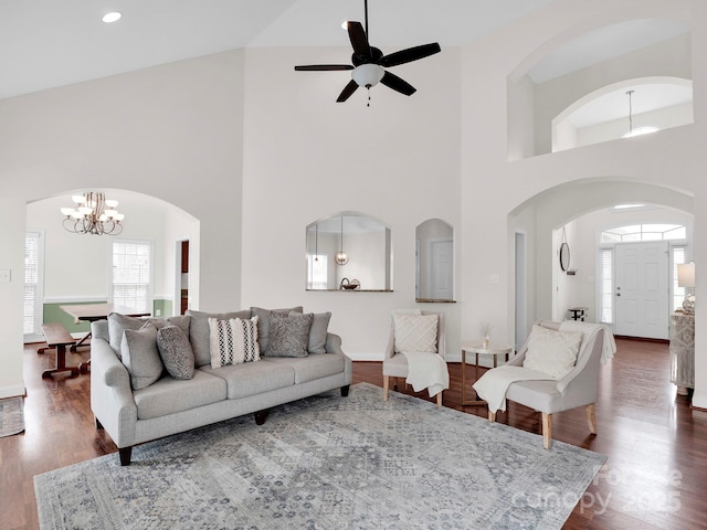 living area featuring recessed lighting, ceiling fan with notable chandelier, arched walkways, and dark wood-style flooring