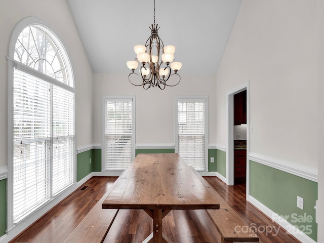 dining space with an inviting chandelier, dark wood-type flooring, baseboards, and high vaulted ceiling