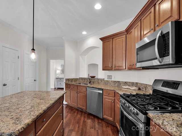 kitchen with light stone counters, dark wood-style flooring, arched walkways, a sink, and appliances with stainless steel finishes