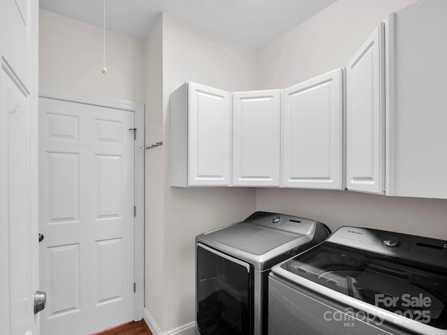 washroom featuring attic access, washing machine and dryer, cabinet space, and baseboards