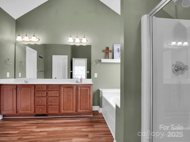 bathroom featuring wood finished floors, a shower, a garden tub, and a sink