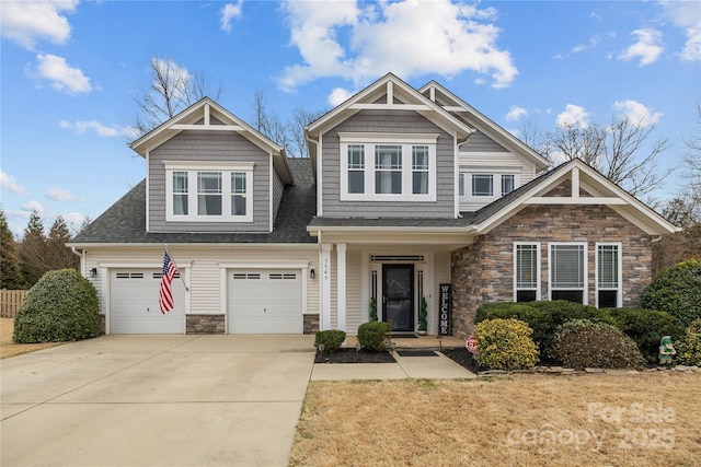 craftsman-style home featuring stone siding, driveway, and an attached garage