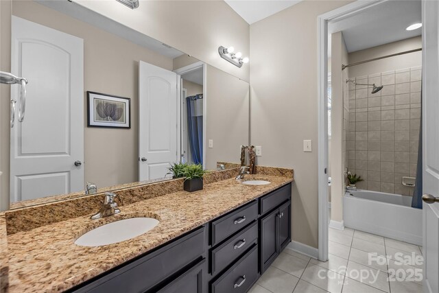 bathroom featuring tile patterned floors, double vanity, baseboards, and a sink