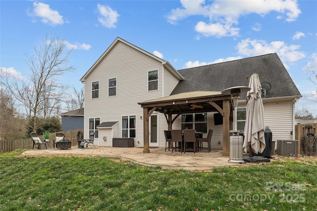 rear view of property with a patio area, a fire pit, a lawn, and fence