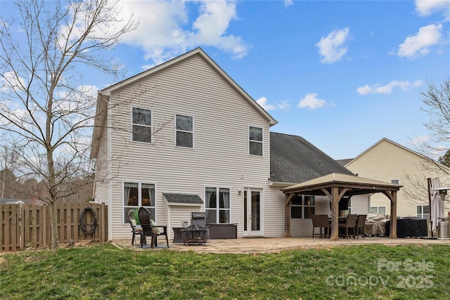 back of house featuring fence, an outdoor fire pit, a gazebo, a lawn, and a patio area