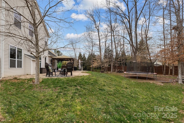 view of yard featuring a gazebo, fence, a trampoline, and a patio area