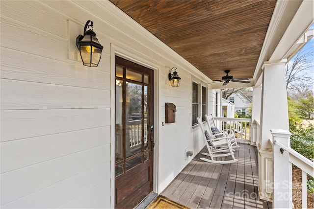 wooden deck featuring covered porch and ceiling fan