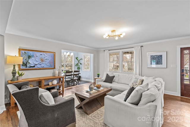 living area featuring a notable chandelier, wood-type flooring, and ornamental molding