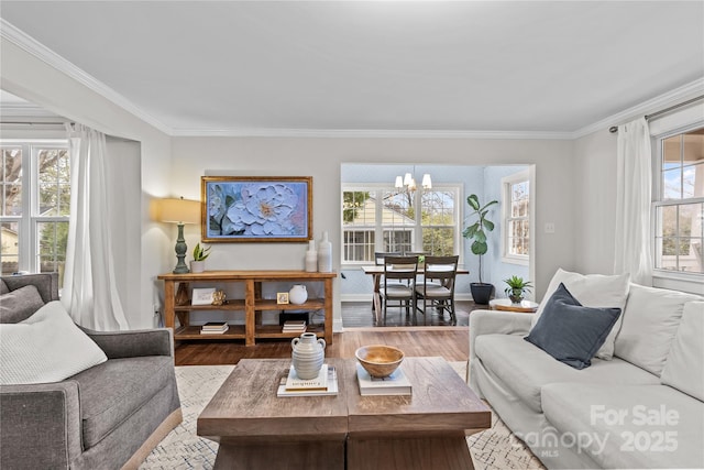 living area featuring crown molding, wood finished floors, baseboards, and a chandelier