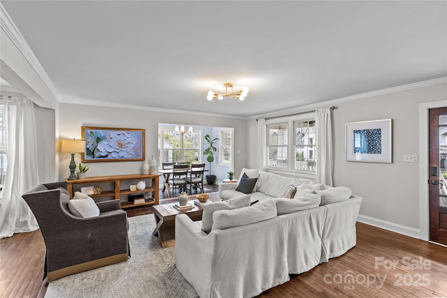 living room featuring a wealth of natural light, wood finished floors, a chandelier, and crown molding