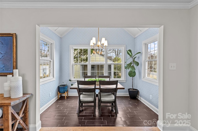 dining area with baseboards, wood finish floors, wallpapered walls, an inviting chandelier, and crown molding