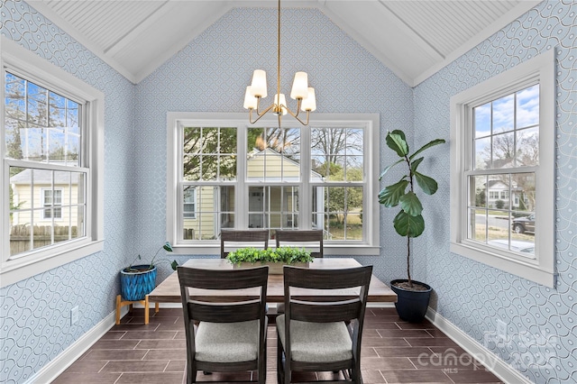 sunroom featuring lofted ceiling, plenty of natural light, and an inviting chandelier