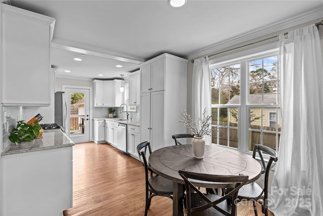 dining area with recessed lighting, crown molding, and light wood-style floors