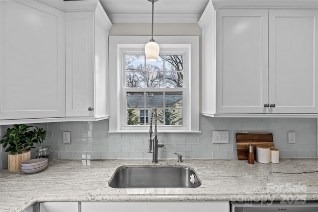 kitchen with backsplash, dishwasher, white cabinetry, and a sink