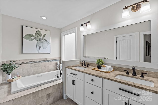 bathroom featuring a bath, double vanity, and a sink