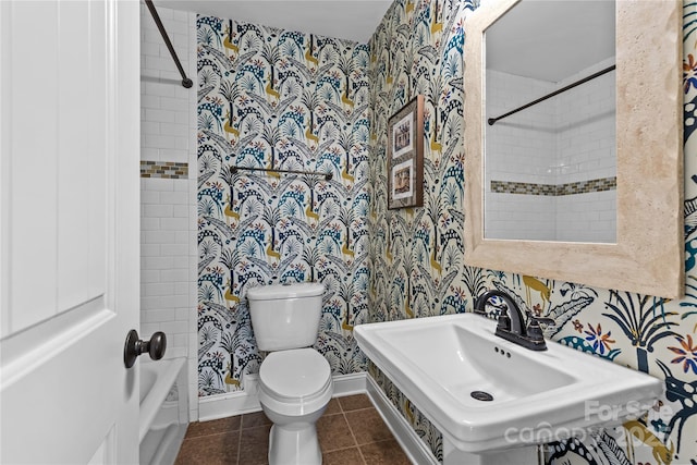 full bathroom featuring wallpapered walls, baseboards, toilet, tile patterned floors, and a sink