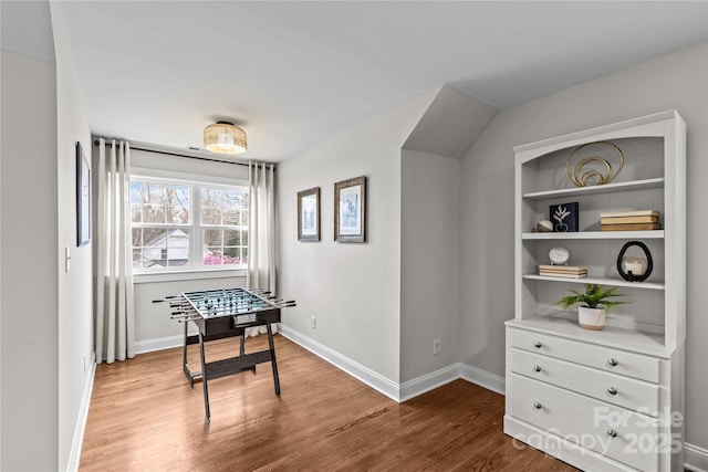 rec room with baseboards and wood finished floors