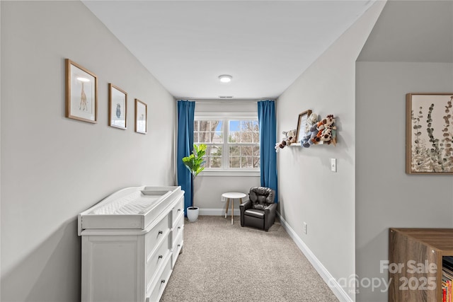 sitting room featuring carpet flooring and baseboards