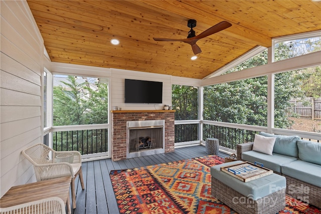 sunroom with a wealth of natural light, wooden ceiling, ceiling fan, and vaulted ceiling