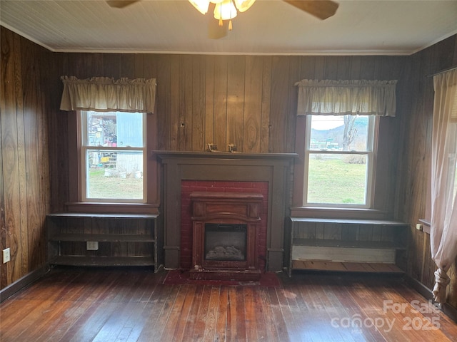 unfurnished living room featuring ornamental molding, ceiling fan, a fireplace, and hardwood / wood-style flooring