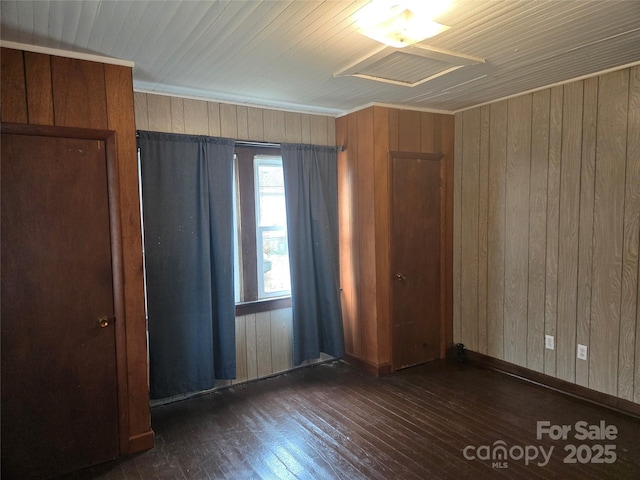 unfurnished bedroom featuring wood walls and hardwood / wood-style flooring