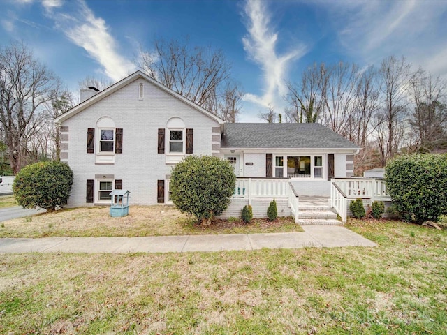 view of front of home with brick siding, a chimney, and a front yard