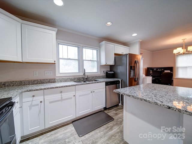 kitchen featuring a sink, stainless steel appliances, white cabinets, and ornamental molding